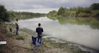 FILE - This Nov. 12, 2016, file photo shows Isaac Aguilar, left, and Isac Ramos, right, fishing on the banks of the Rio Grande in Los Ebanos, Texas. P
