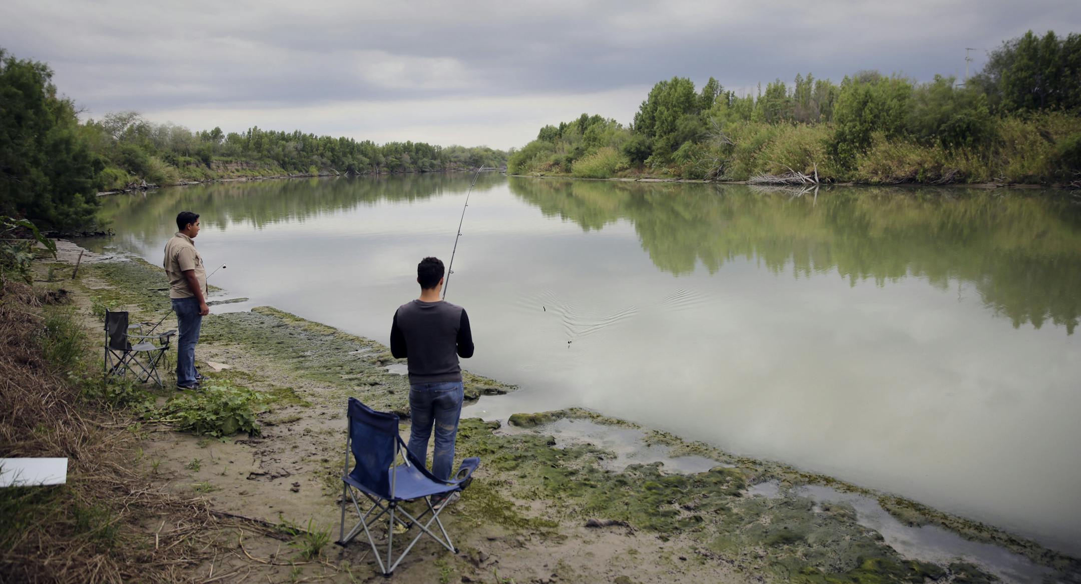 FILE - This Nov. 12, 2016, file photo shows Isaac Aguilar, left, and Isac Ramos, right, fishing on the banks of the Rio Grande in Los Ebanos, Texas. President Donald Trump will face many obstacles in building his ìbig, beautiful wallî on the U.S.-Mexico border, including how to pay for it and how to contend with unfavorable geography and the legal battles ahead. (AP Photo/Eric Gay, File)