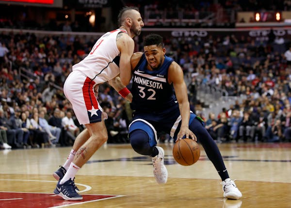 Timberwolves center Karl-Anthony Towns (32) drives against Wizards center Marcin Gortat during the first half of Tuesday's game.