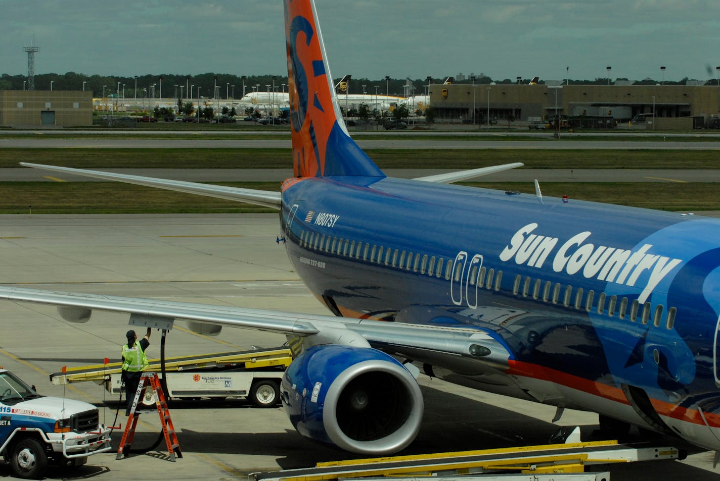 A Sun Country Airlines Boeing 737-800 is fueled on the tarmac at MSP Humphrey Terminal.