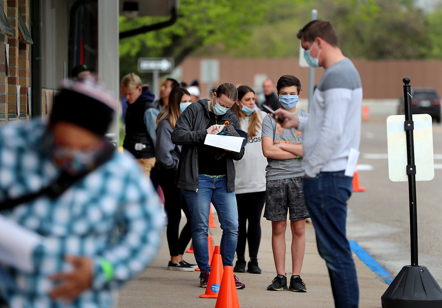 Sixteen DVS exam stations reopened Tuesday, including this one in Arden Hills where during the mid-morning an estimated 200 people waited outside in a line that stretched around the entire block to get into the building Tuesday, May 19, 2020, in Arden Hills, MN.]