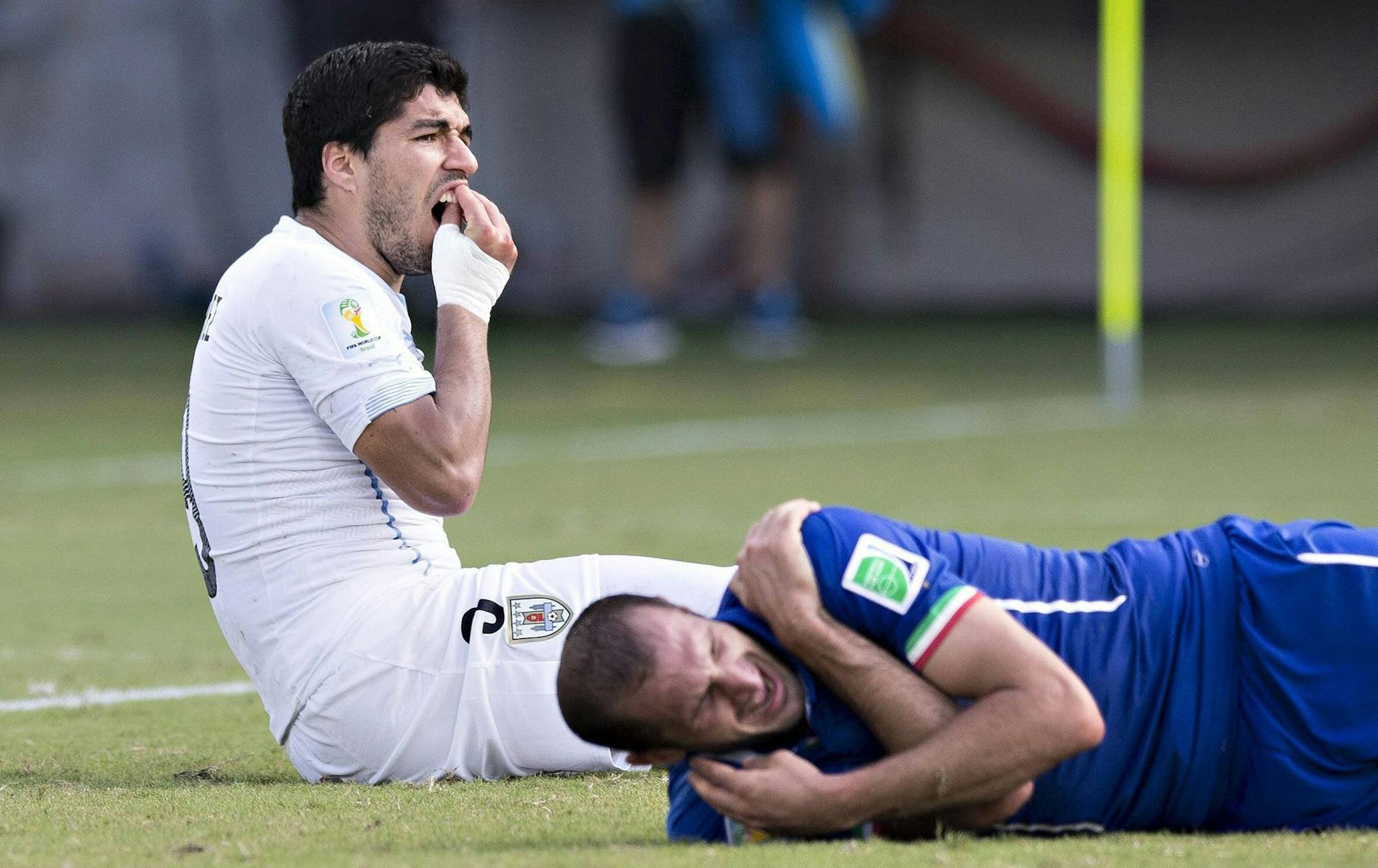 Luiz Suarez of Uruguay touches his teeth after coming into contact with Giorgio Chiellini of Italy during FIFA World Cup in Natal, Brazil, on June 24, 2014. (Imago/Zuma Press/MCT)