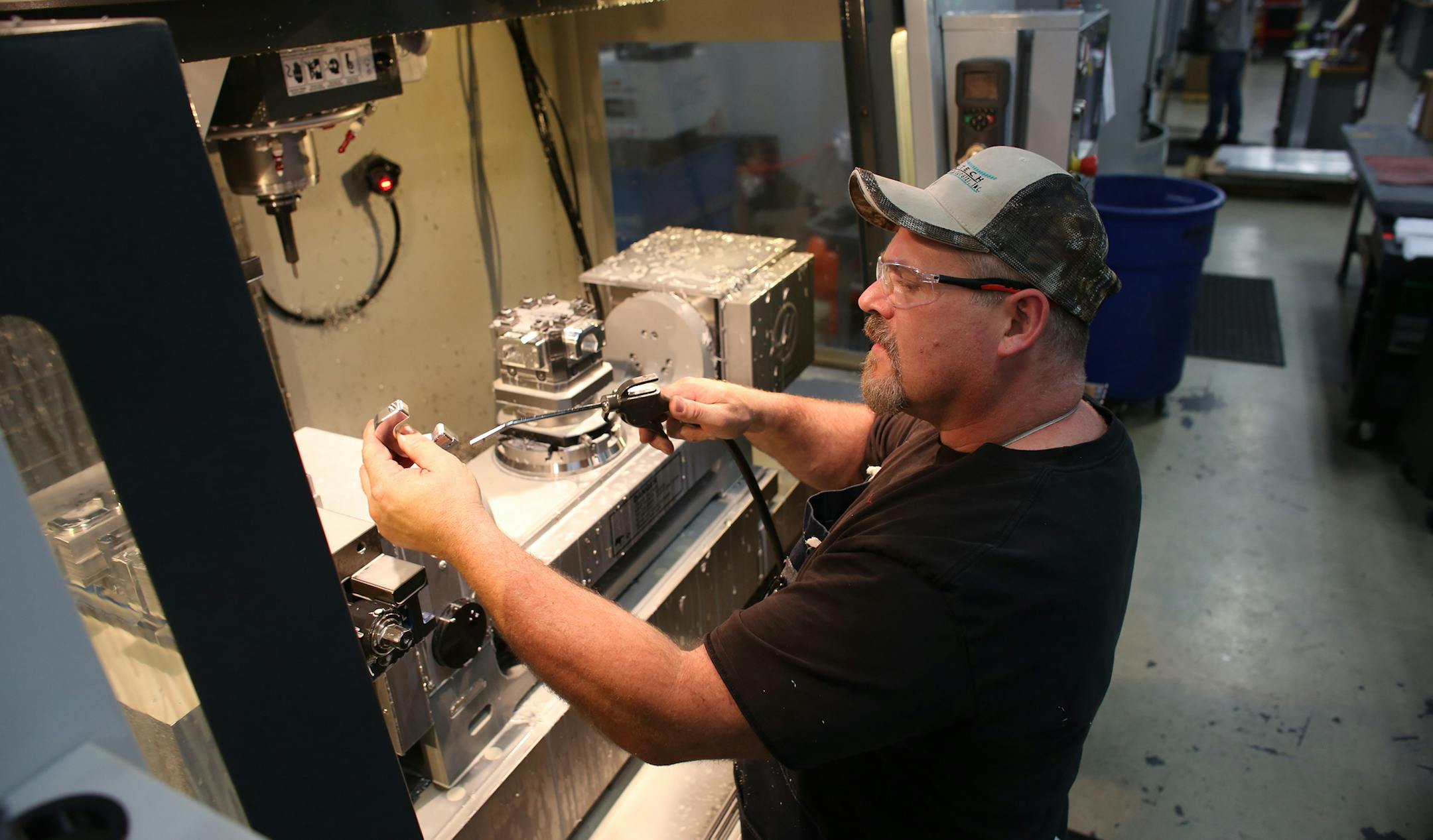 Blaine Weber removed and cleaned off newly cut clamps for a medical IV poles four at a time from a vertical machine center. President Mike Yeager paid $10,500 in sales taxes on this machine. Starting July 1st that sales tax goes away. ] (KYNDELL HARKNESS/STAR TRIBUNE) kyndell.harkness@startribune.com At Yeager Machine in Norwood Young America Min., Tuesday, June 30, 2015.