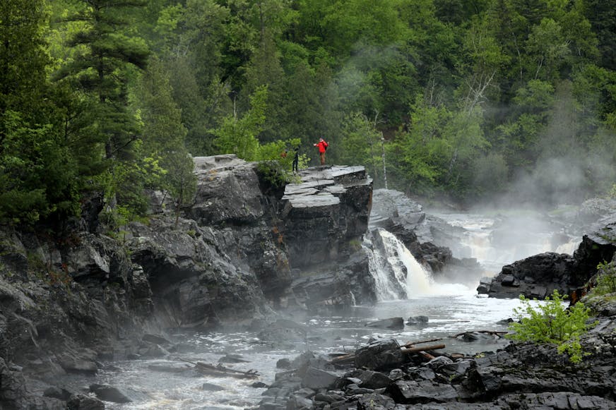 Hikers cross the spectacular rocky gorge of the lower St. Louis River in Jay Cooke State Park along the Superior Hiking Trail.