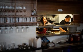 Sina War puts a plate on the warmer as she prepares a meal for the first Immigrant Kitchen dinner at Harriet Brasserie in Minneapolis in April. The im