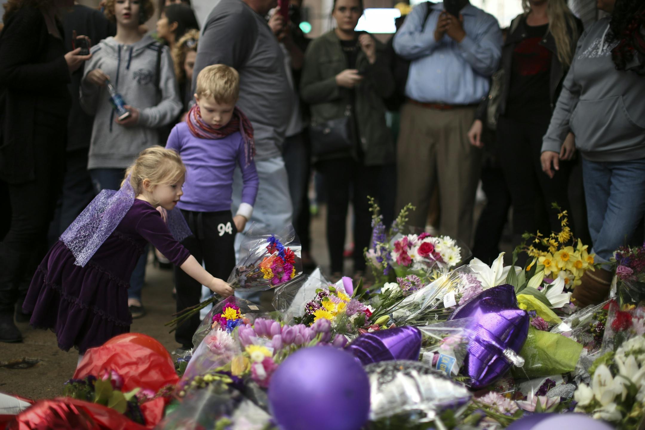 The growing memorial under Prince's star at First Ave. drew multitudes of fans throughout Tuesday afternoon and evening. Eleanor Loe, 4, and her brother, Henry, 6, both left bouquets at the memorial.