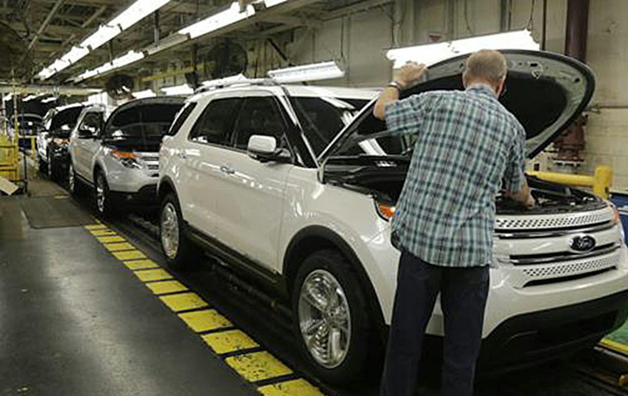 In this Oct. 22, 2014 photo, workers perform final inspections on 2015 Ford Explorers on the assembly line at the Chicago Ford Assembly Plant in Chicago. The Commerce Department releases durable goods for September on Tuesday, Oct. 28, 2014. (AP Photo/M. Spencer Green)