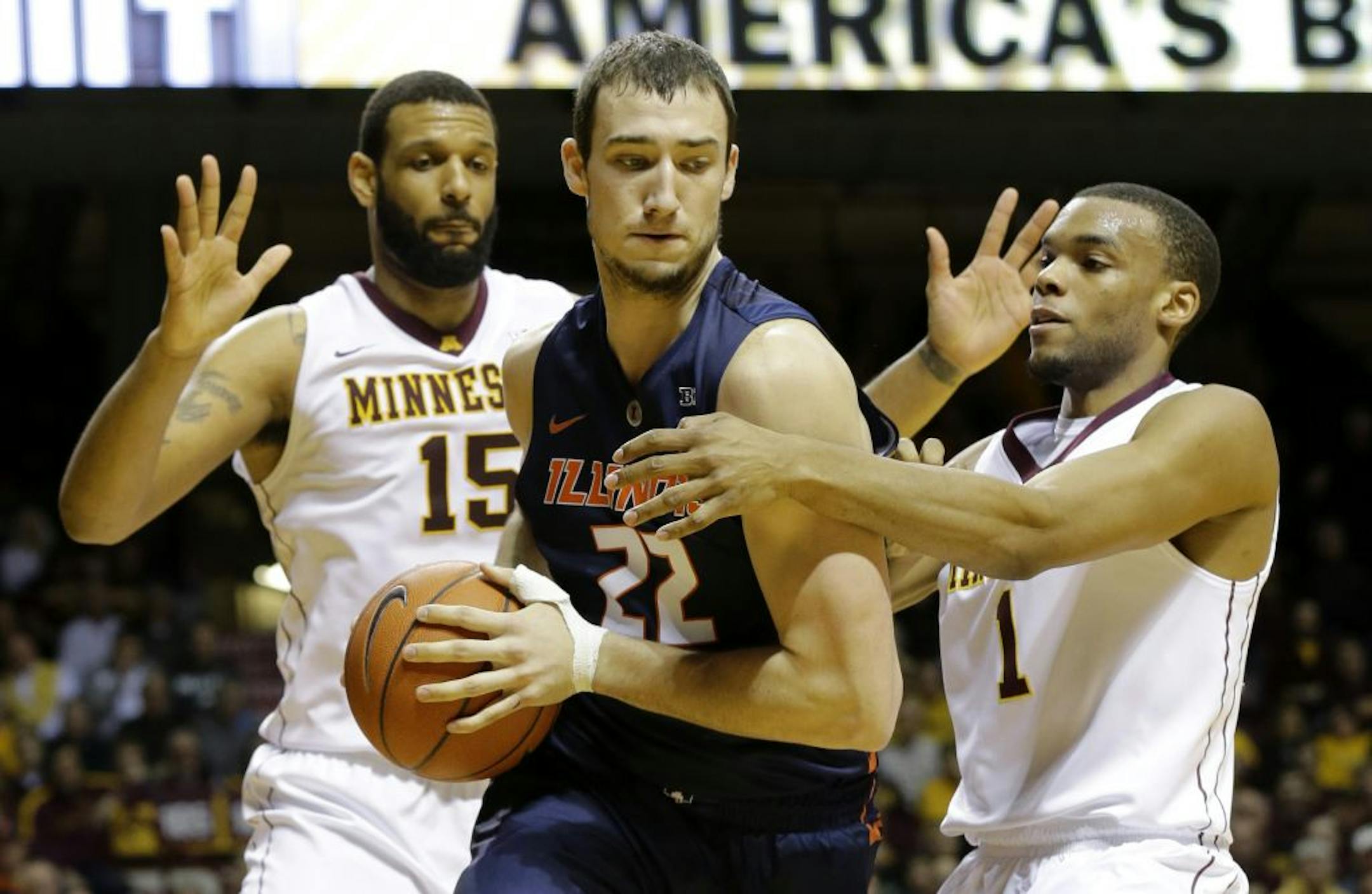 Illinois center Maverick Morgan (22) is trapped by Minnesota forward Maurice Walker (15) and guard Andre Hollins (1) during the first half of an NCAA college basketball game in Minneapolis, Saturday, Jan. 24, 2015.