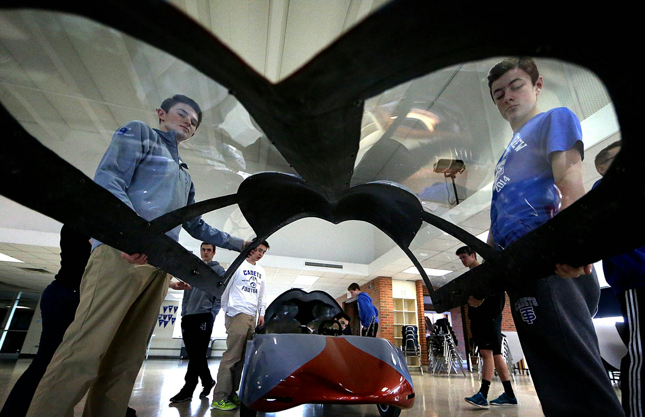 Davis Hesdorffer (left) and Jack Kotok lifted the front portion of the car, including wind shield, into place. ] JIM GEHRZ ï james.gehrz@startribune.com /Minneapolis, MN / March 25, 2016 1:30 PM - BACKGROUND INFORMATION: The Shell Eco-Marathon tests students' design and construction skills, asking them to create energy-efficient vehicles which can look like the furthest thing from traditional cars. Two Minnesota schools are competing in the challenge in April and are immersing themselves in