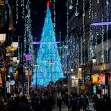 People walk past Christmas lights in downtown Madrid, Spain, Tuesday, Dec. 21, 2021. Despite vaccination rates that make other governments envious, Spain and Iberian neighbor Portugal are facing the hard truth that these winter holidays won't be a time of unrestrained joy. The reason is the new omicron variant that has been running rampant across Europe. (AP Photo/Bernat Armangue)