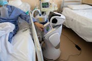 In this file photo, a COVID-19 patient uses the touch screen of a health care robot at 'Ospedale di Circolo' hospital, in Varese, Italy on Wednesday, 