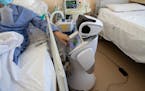 In this file photo, a COVID-19 patient uses the touch screen of a health care robot at 'Ospedale di Circolo' hospital, in Varese, Italy on Wednesday, 