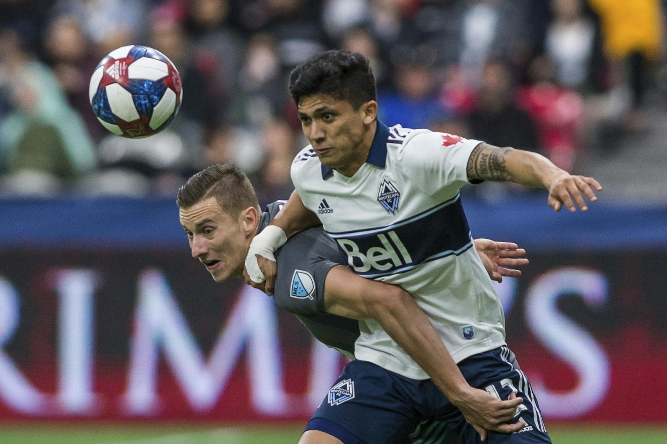 Minnesota United's Jan Gregus plays the ball against Vancouver Whitecaps' Fredy Montero (12) during the second half of an MLS soccer match Saturday, March 2, 2019, in Vancouver, British Columbia.