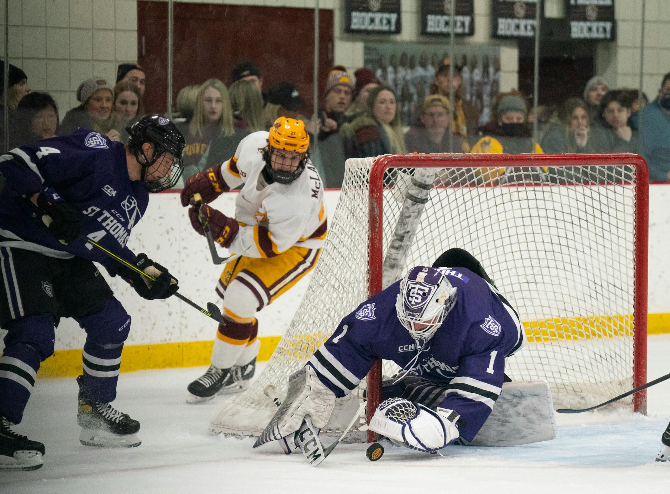 Tommies goaltender Peter Thome (1) covered up the loose puck before Gophers forward Blake McLaughlin (27) could get to it in the third period Sunday afternoon, Jan. 2, 2022 at Doug Woog Arena in South St. Paul. At left was Tommies defenseman Nolan Sawchuk (4).