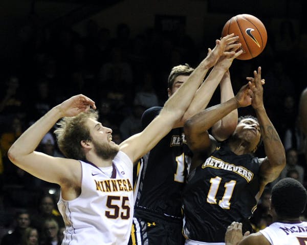 Maryland-Baltimore County guard Will Darley, center, and guard Charles Taylor (11) reach for a rebound with Minnesota center Elliott Eliason (55) duri