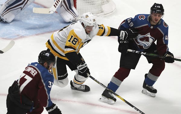 Pittsburgh Penguins center Alex Galchenyuk, center, pursues the puck with Colorado Avalanche left wing J.T. Compher, left, and defenseman Samuel Girar