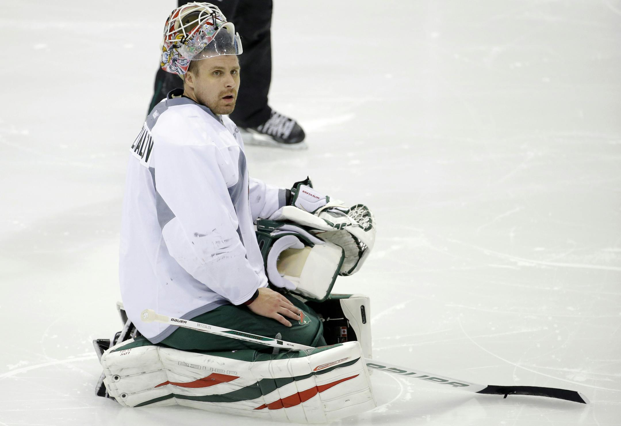 Minnesota Wild goalie Ilya Bryzgalov, of Russia, kneels on the ice during NHL hockey training camp in St. Paul, Minn., Friday, Sept. 19, 2014. (AP Photo/Ann Heisenfelt)