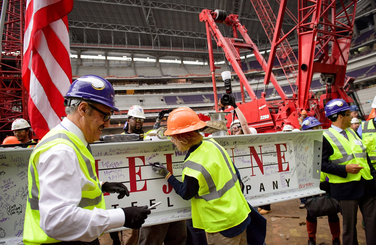 Flanked by Zygi and Mark Wilf, Lt. Governor Tina Smith signed the beam. ] GLEN STUBBE * gstubbe@startribune.com Thursday September 16, 2015 A "topping out" ceremony for the new Minnesota Vikings stadium, marking the highest or last piece of steel placed on a building. Mark Wilf and Lt. Gov. Tina Smith were there. Heavy rain and lightening in the area made it unsafe to hoist the steel beam to the roof. Workers were treated to a free pork chop lunch.