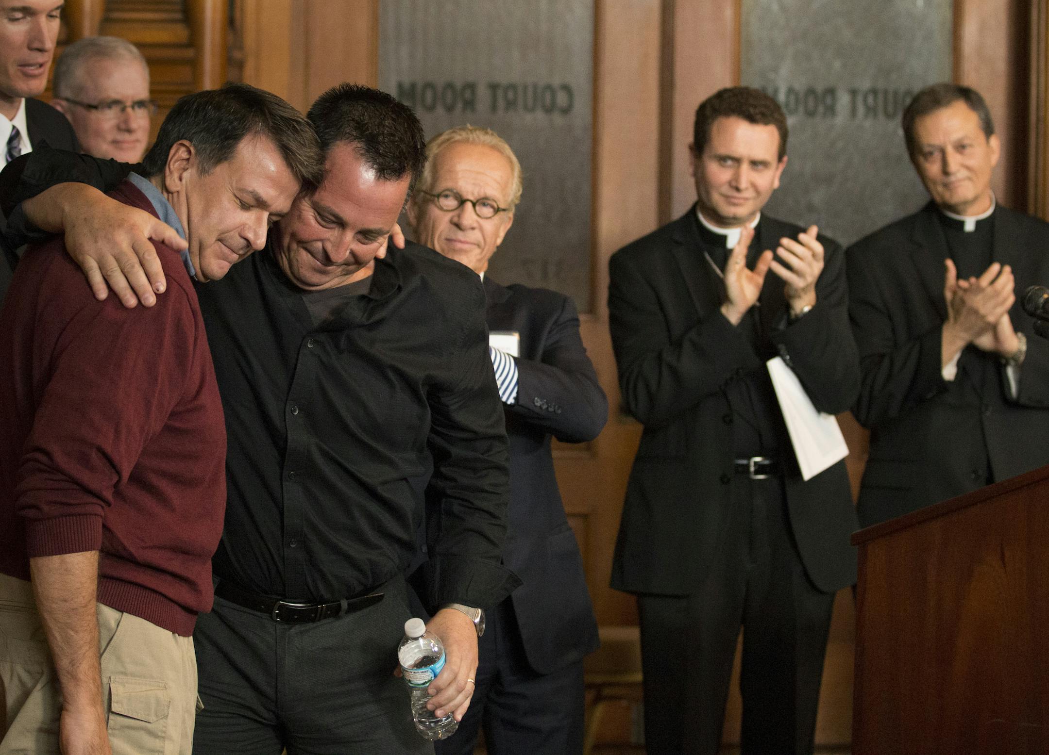 Abuse survivors Al Michaud (left) and Jim Keenan embrace after they both spoke of the importance of this historic agreement. Atourney Jeff Anderson, Bishop Andrew Cozzens and Vicar General Rev. Charles Lachowitzer at right look on. ] Twin Cities Archdiocese Vicar General, Rev. Charles Lachowitzer said, church officials would work with St. Paul attorney Jeff Anderson to implement the terms of a settlement of a landmark clergy sex abuse lawsuit. ‚ÄúWe‚Äôve forged