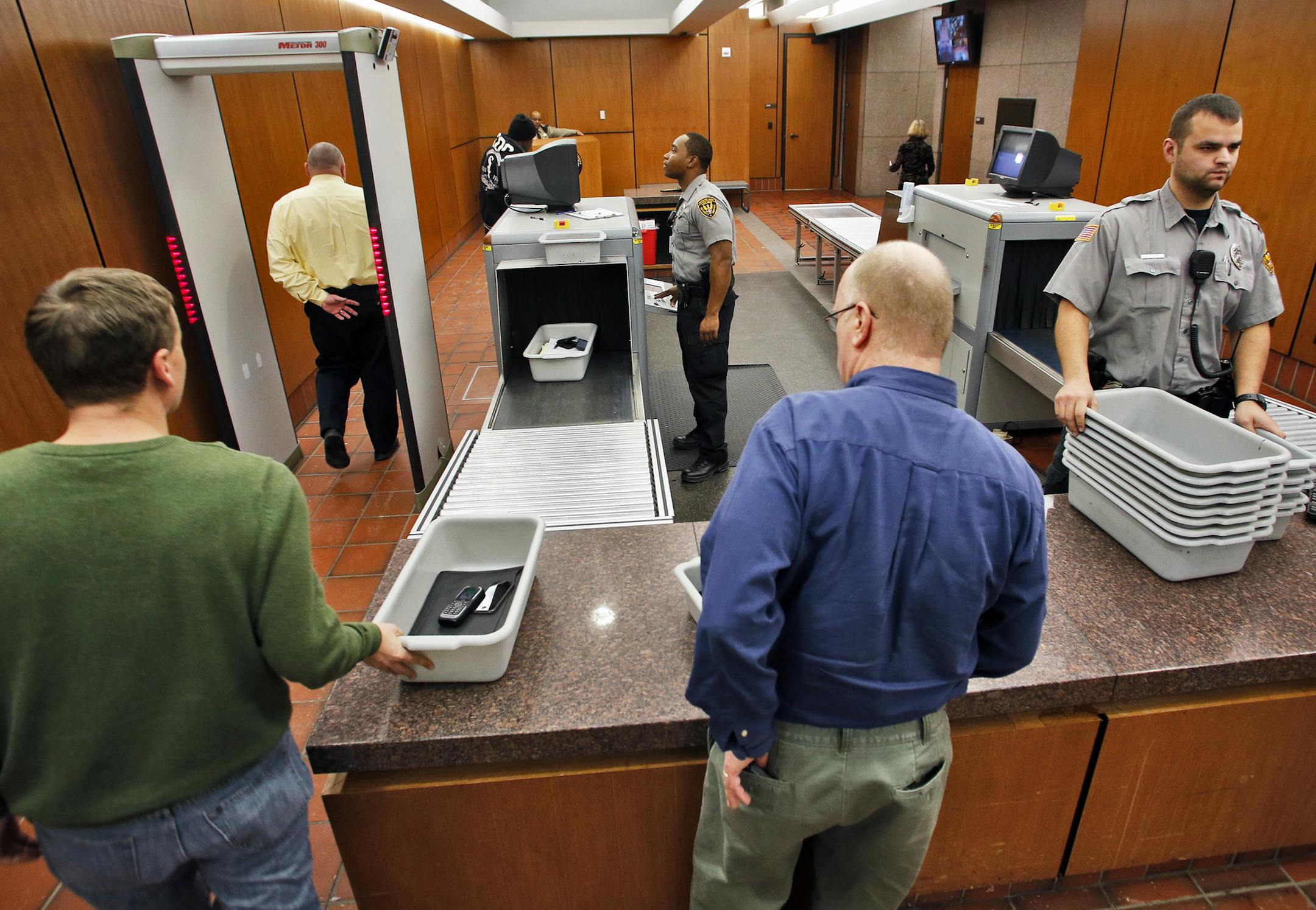 Courthouse screening is expanding in the metro area. A visual look at the screening area of the Hennepin County Government Center in Minneapolis. Viking Security agents Carlo Griggs, left, and Jon Kline checked people as they proceeded through the security machines. (MARLIN LEVISON/STARTRIBUNE(mlevison@startribune.com)