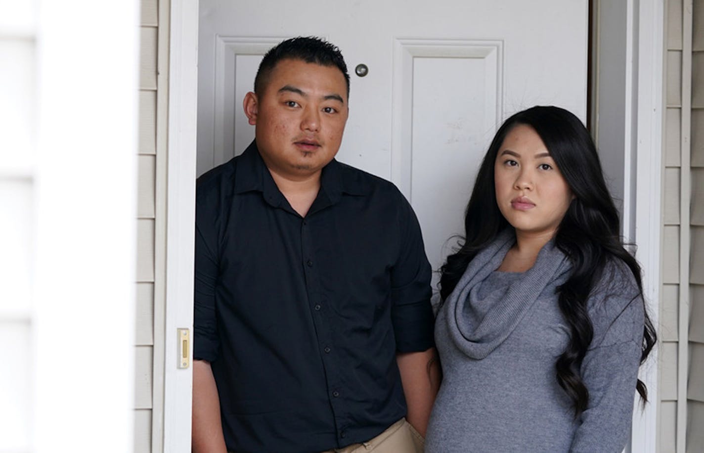 Alvin Moua and his wife, Vanishia Yang, stood outside their home, where someone left a racist, threatening note on their door linking them to the coronavirus pandemic.