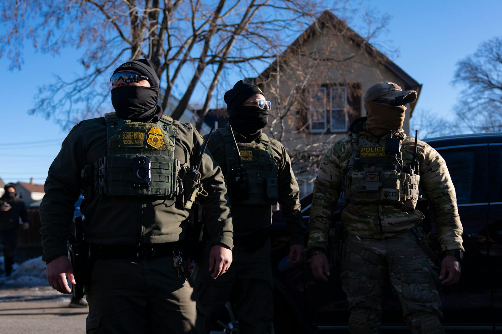ICE agents walk down a block near 31st St. and Portland Ave. to confront observers and members of the press for following them in Minneapolis on Wednesday, Jan. 14.

