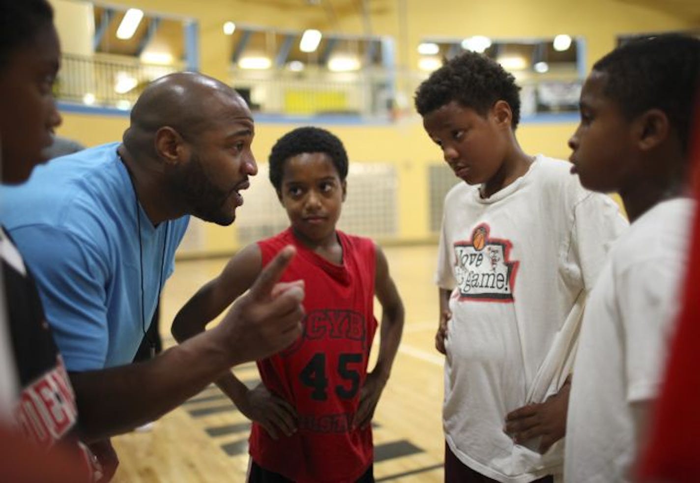 Khalid El-Amin coached a youth team at the Boys and Girls Club that included his 11-year-old son, Ishmael, second from right. El-Amin plays professional basketball overseas, including last season in the Ukraine.