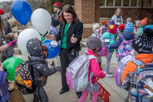 Lake Harriet Lower Principal Angie Ness welcomes students back to school in Minneapolis, Minn., on Tuesday.