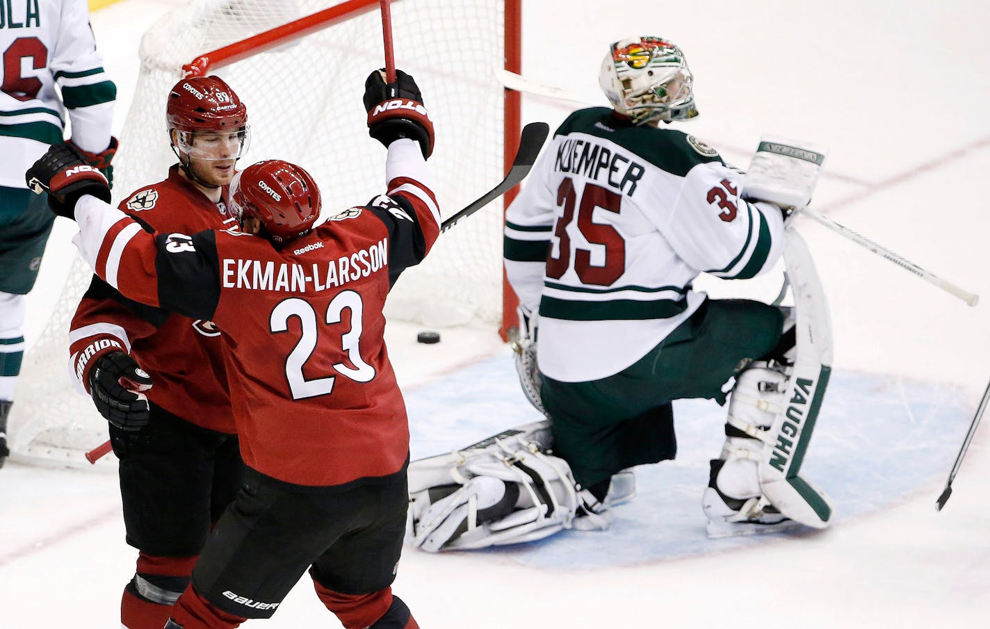 Arizona Coyotes' Mikkel Boedker (89), of Denmark, celebrates his game-winning goal against Minnesota Wild's Darcy Kuemper (35) with Coyotes' Oliver Ekman-Larsson (23), of Sweden, during overtime of an NHL hockey game Friday, Dec. 11, 2015, in Glendale, Ariz. The Coyotes won in overtime 2-1. (AP Photo/Ross D. Franklin)