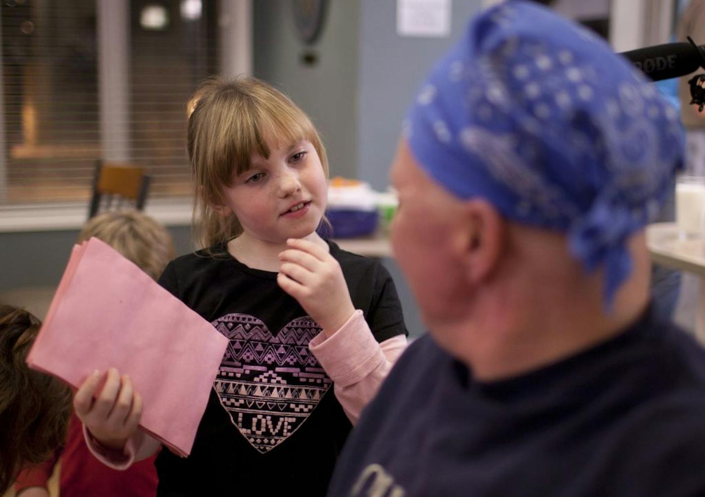 Carly Glomstad, 7, with some help from her brother, Brian, 9, distributed Valentines and goody bags to guests and caregivers at the American Cancer Society Hope Lodge in Minneapolis Monday night. Carly Glomstad visited with Hope Lodge guest Troy Makela of Loretto, Minn. after giving him and his fiancé Valentines and Girl Scout cookies Monday night. The Plymouth youngster is spearheading a campaign to "deliver goody bags to these people and make them smile." She raised the money for the project h