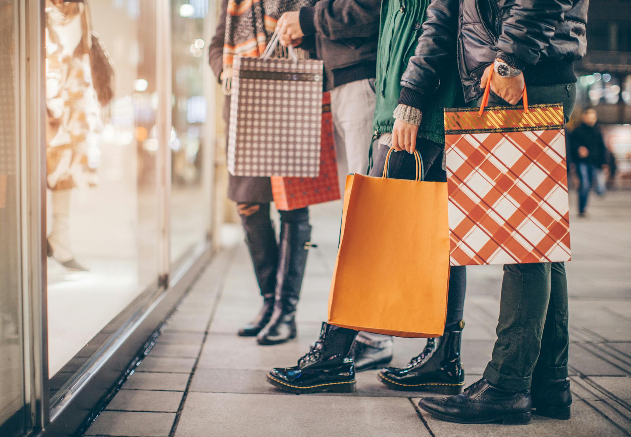 Friends window shopping outdoors in winter city street. Vienna, Austria.