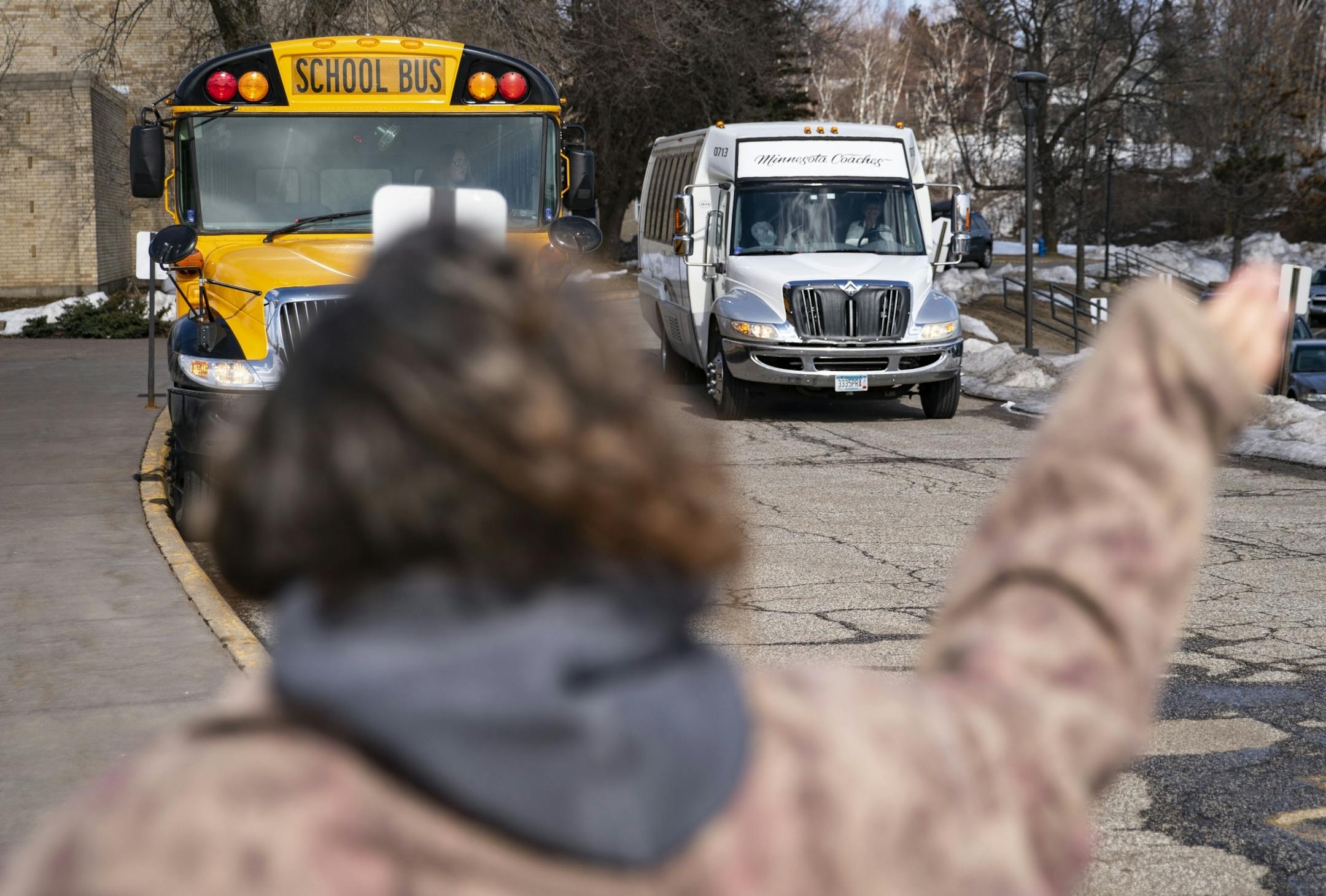 Parents waved, shook bells and honked their car horns as the bus carrying the Duluth Marshall girl's basketball team pulled into the school parking lot on Friday afternoon.