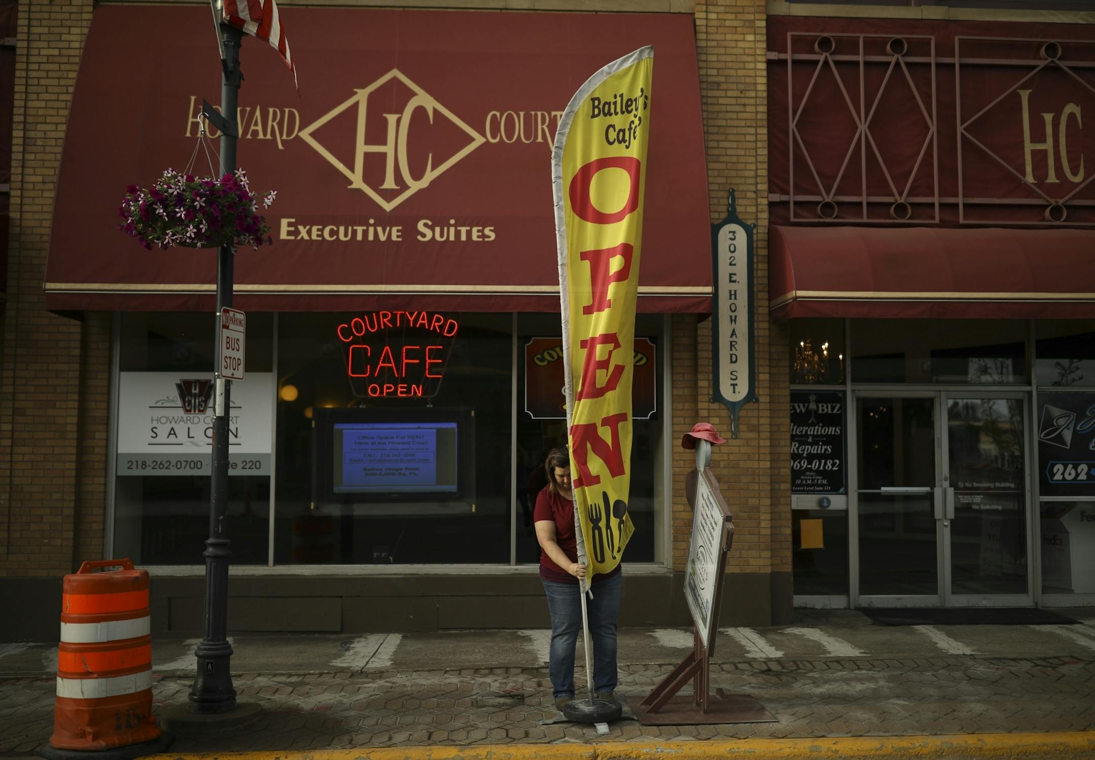 Tracy Bailey mounted the flag for her Bailey's Courtyard Cafe shortly after she and her husband, Jim, opened up for the day Thursday morning on E. Howard St. in downtown Hibbing.
