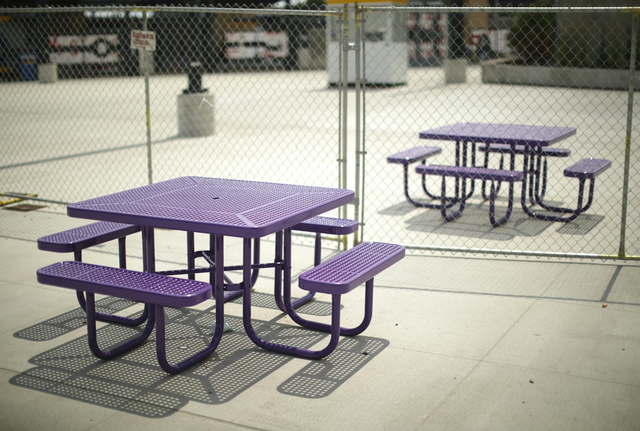 A chain link fence separated picnic tables on the plaza across from U.S. Bank Stadium.