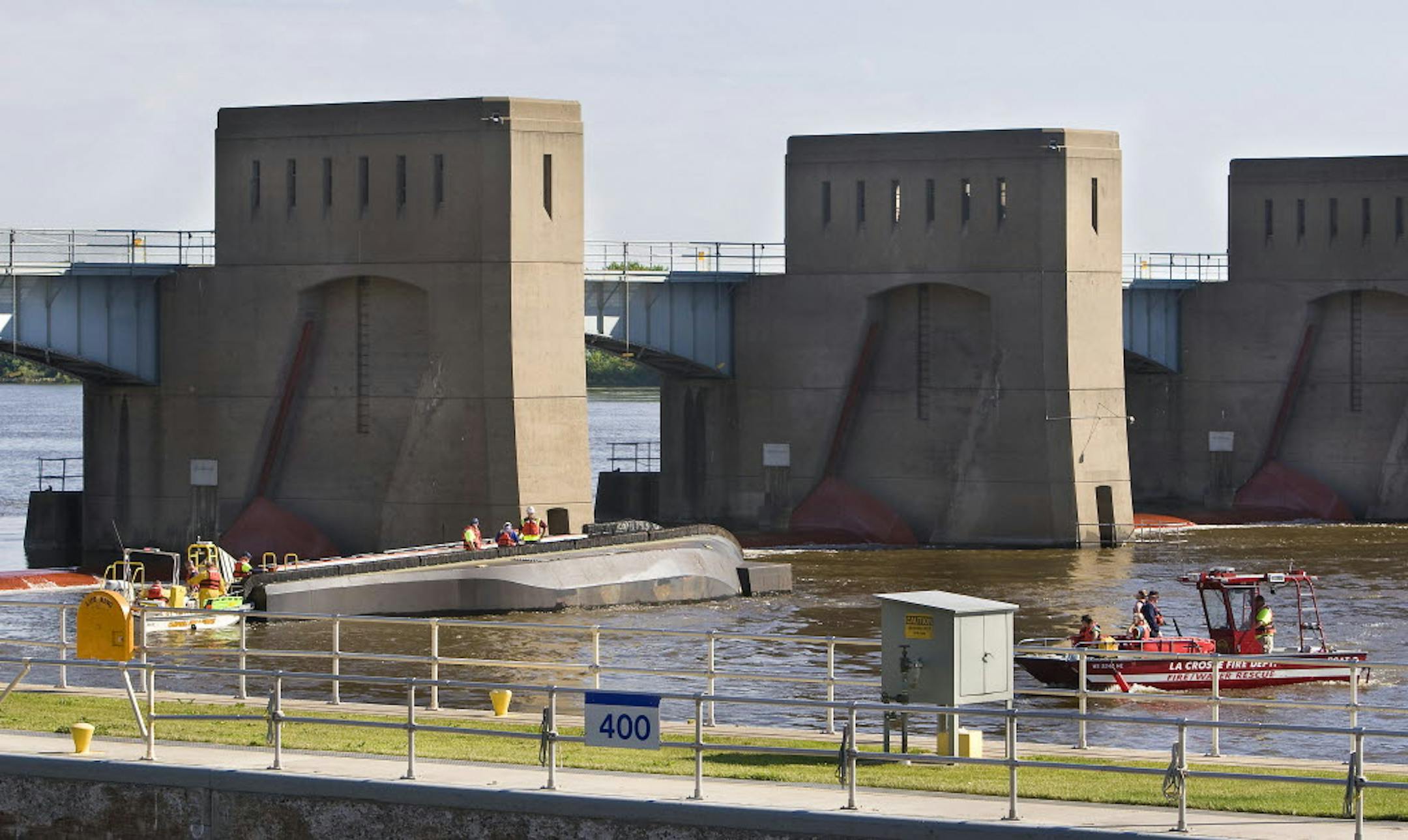 Rescue workers search the area and attempt to gain access to an overturned barge that went over Lock & Dam #7 at La Crescent, Minn., on the Mississippi River Wednesday morning.