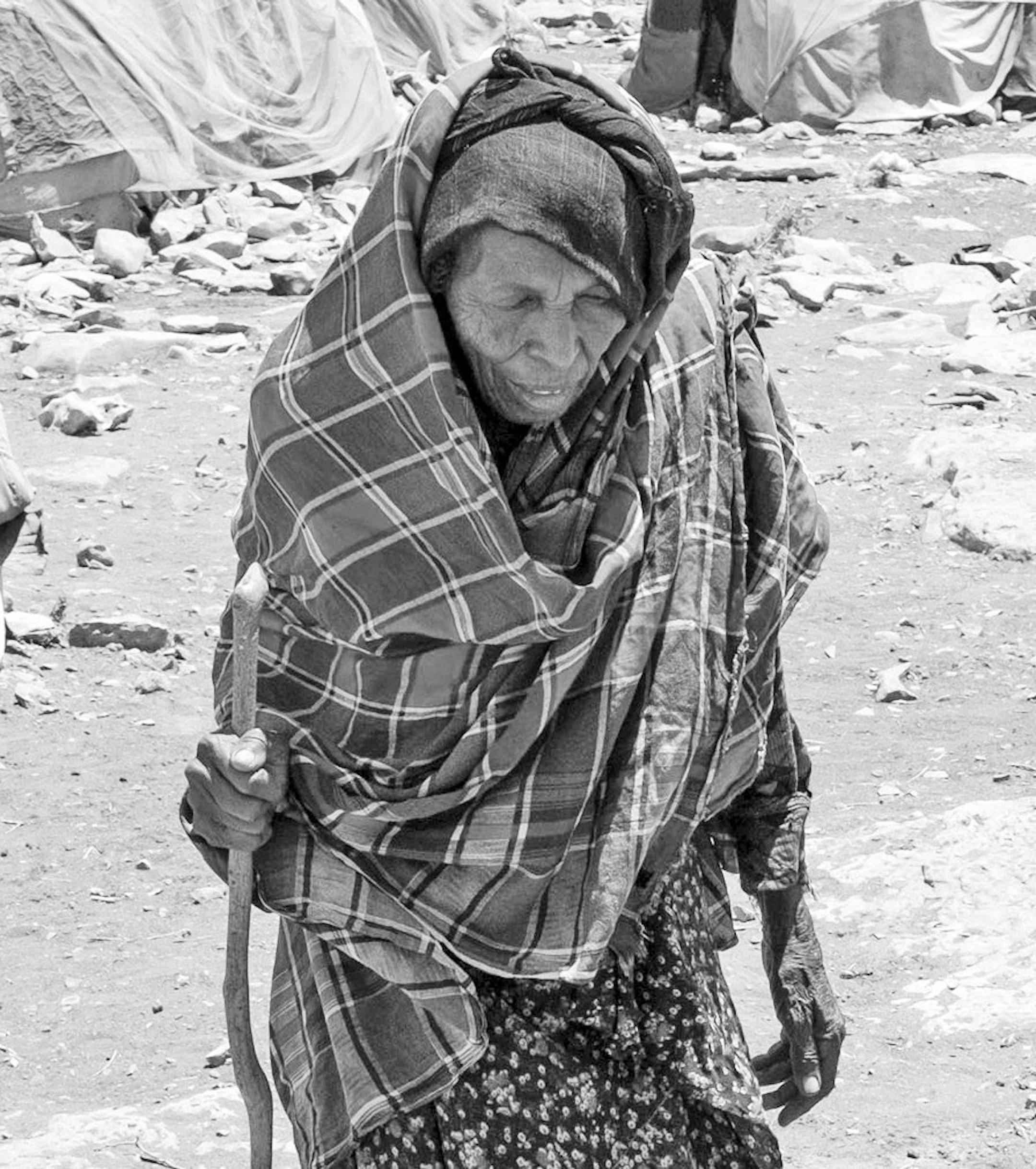 An elderly woman, displaced by the drought in Somalia, walks between makeshift tents at a camp in Baidoa, March 9, 2017. Six years after its last famine, another is about to tighten its grip on Somaliaís food and water supply, with South Sudan, Nigeria and Yemen also at risk. (Tyler Hicks/The New York Times)