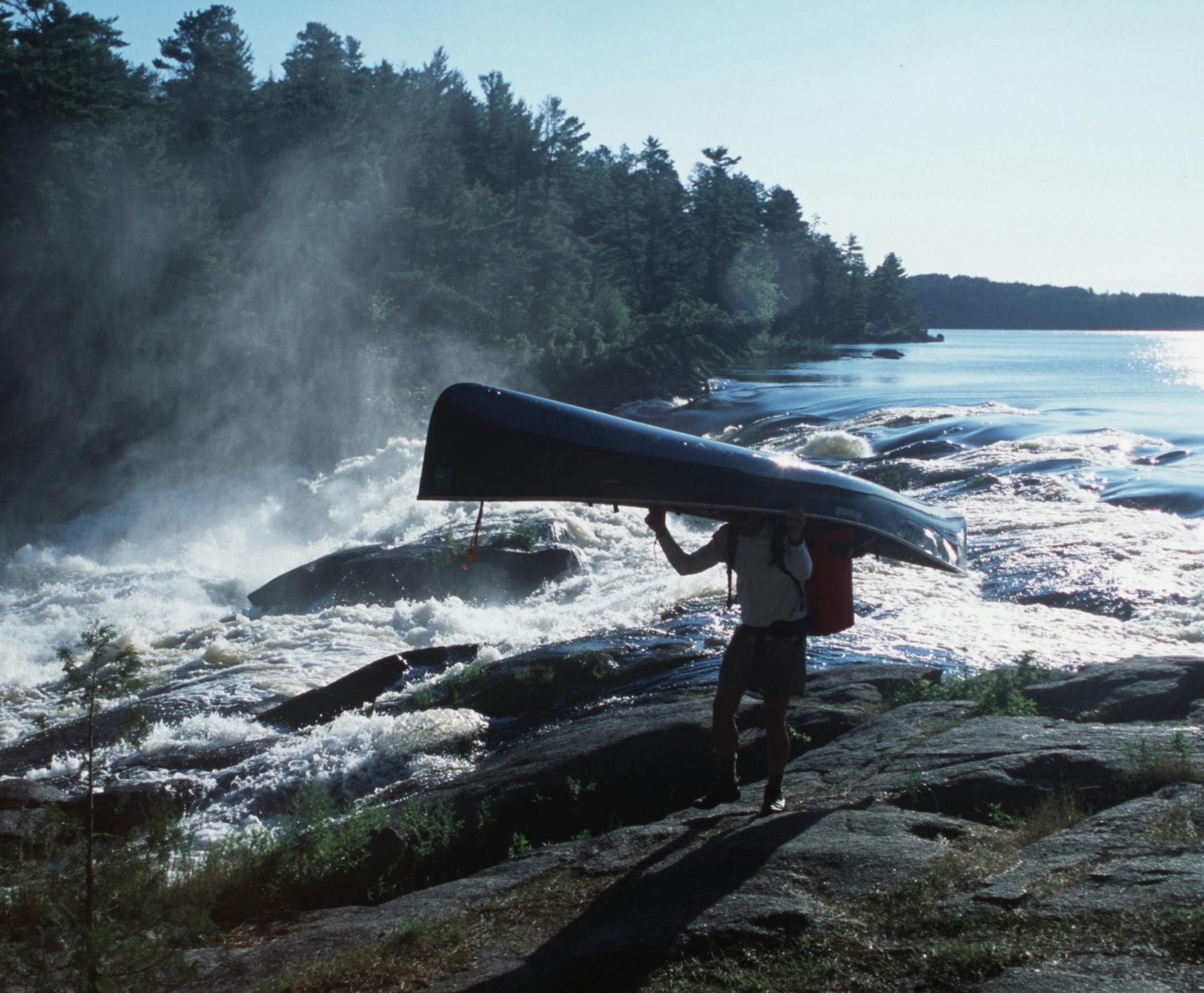 Steve Piragis of Ely MN portages his canoe around roaring Curtain Falls on Crooked Lake along the Minnesota-Ontario border during a late-summer boundary waters trek. This photo ran in color Sunday Sept 9, 2001, page C20. Photo by Star Tribune outdoors writer Doug Smith. ORG XMIT: MIN2013083013065214 ORG XMIT: MIN1308301308090068