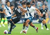 Minnesota United’s Emanuel Reynoso (10) kept the ball away from Puebla’s midfielders when the teams met July 23 at Allianz Field.