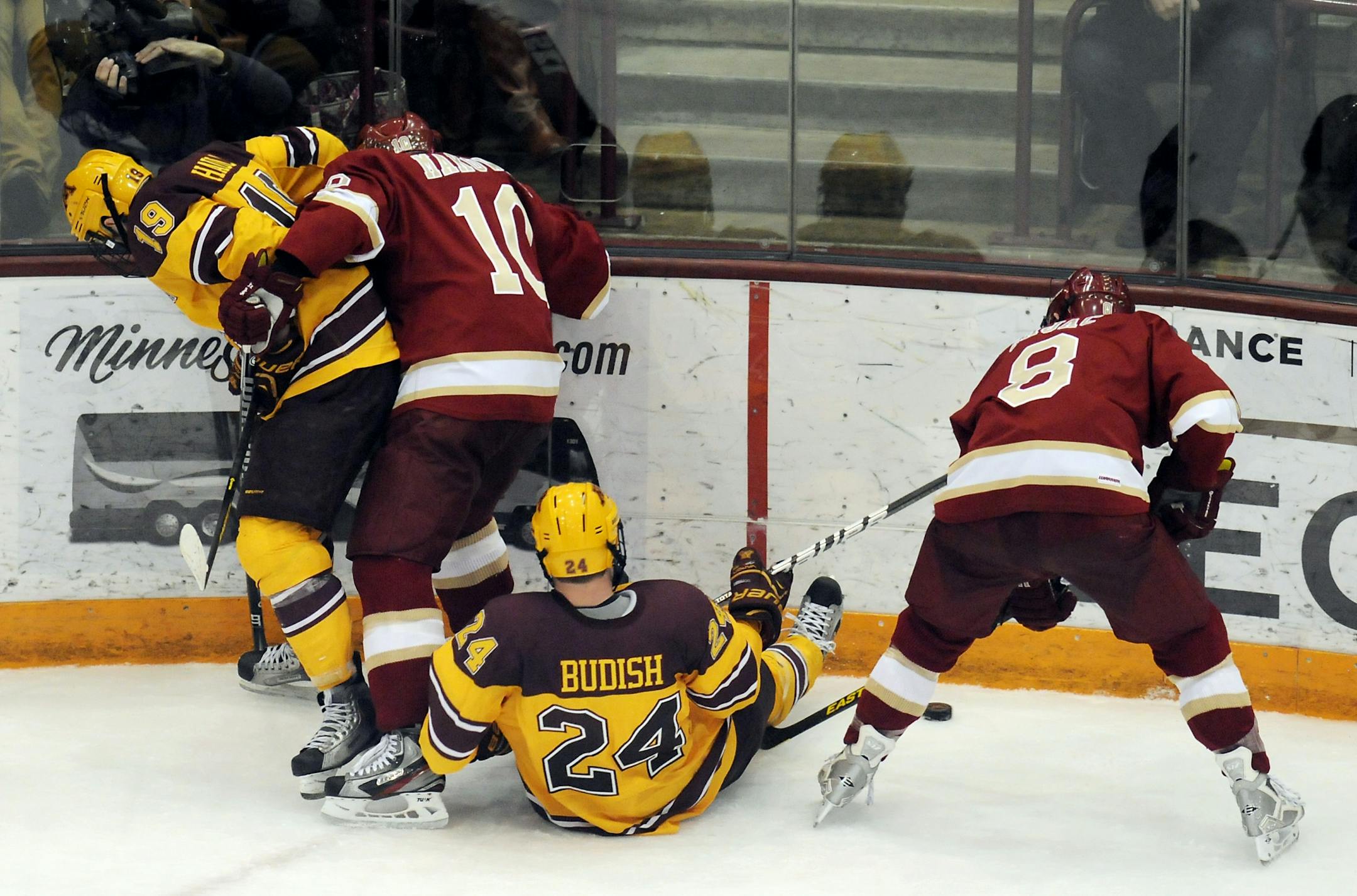 Denver's Nolan Zajac and David Makowski, and Minnesota's Zach Budish and Erik Haula tangle up going for the puck.