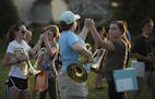 Farmington High School marching band members, including Cas Johnson and Haley Zinnel, right, rehearsed clasping hands at the end of their program, "Dy