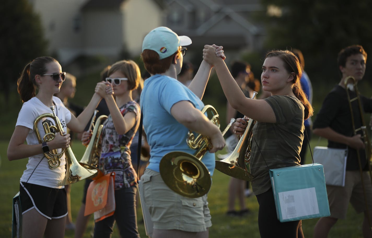 Farmington High School marching band members, including Cas Johnson and Haley Zinnel, right, rehearsed clasping hands at the end of their program, "Dystopia" Thursday night at the school. ] JEFF WHEELER &#xef; jeff.wheeler@startribune.com The Farmington High School marching band has had to revise their halftime program, "Dystopia" slightly after some thought it had political overtones. On Thursday night, the band's rehearsal incorporated the changes while parent volunteers painted new lettering