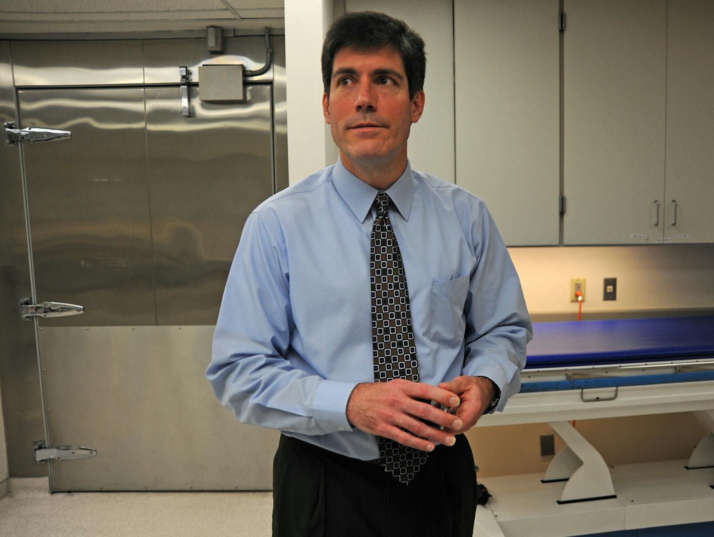 Dr. Andrew Baker is being reappointed to another four-year term as Hennepin County's medical examiner at a time of possible change for the department. The Vikings are staying next door to the morgue but in an even bigger way, prompting talks of moving and possible merger with Dakota County. Standing in the morgue, Baker talked about the history of the office and the current state of the Hennepin County medical examiner's office on Tuesday, June 5, 2012. ] Richard.Sennott@startribune.com Richard