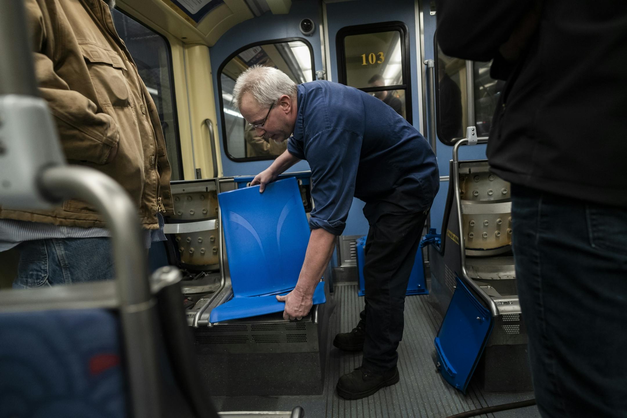 Electromechanical technician Timothy Malmstedt disassembled old cloth seats and installed new plastic seats as part of a test program to try seats that are easier to maintain.