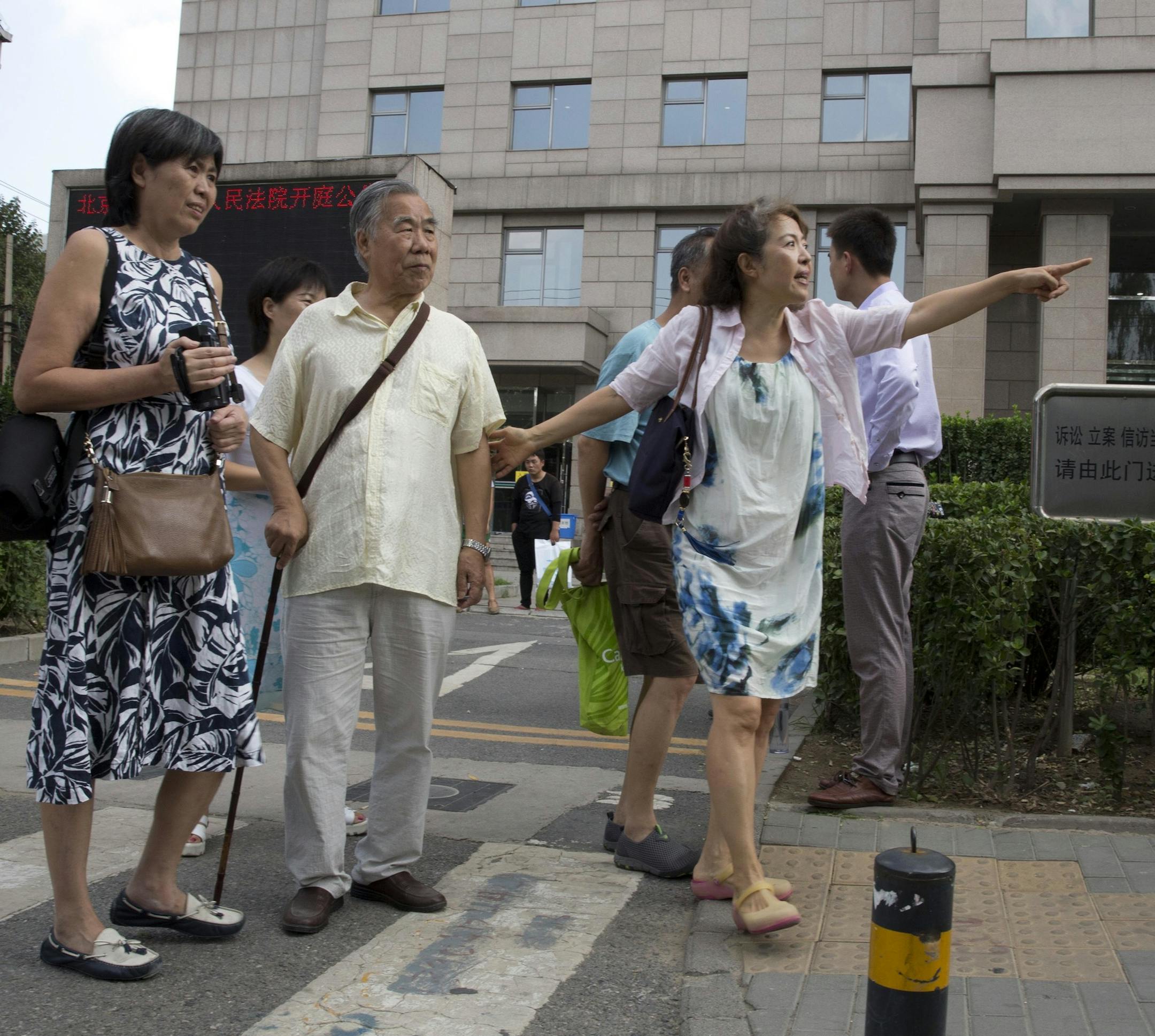 Du Mingling, center, daughter of Du Daozheng, publisher of liberal magazine Yanguang Chunqiu, leads an editor of the magazine outside a courthouse in Beijing, China, Tuesday, Aug. 16, 2016. The ousted editors of the liberal Chinese magazine are suing the government in an effort to wrest back control of one of the country's best-known political journals.(AP Photo/Ng Han Guan) ORG XMIT: XHG115