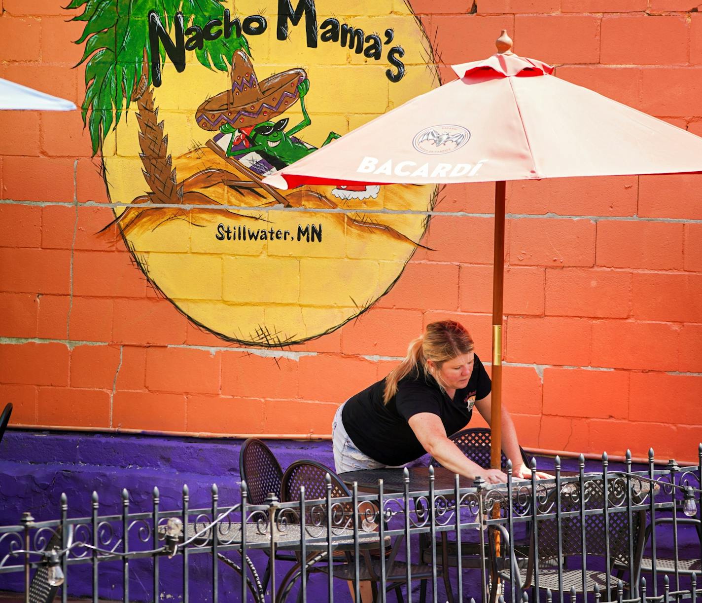 Callie Dunn, manager of Nacho Mama's in Stillwater sanitized her restaurant's deck seating just before the restaurant opened.