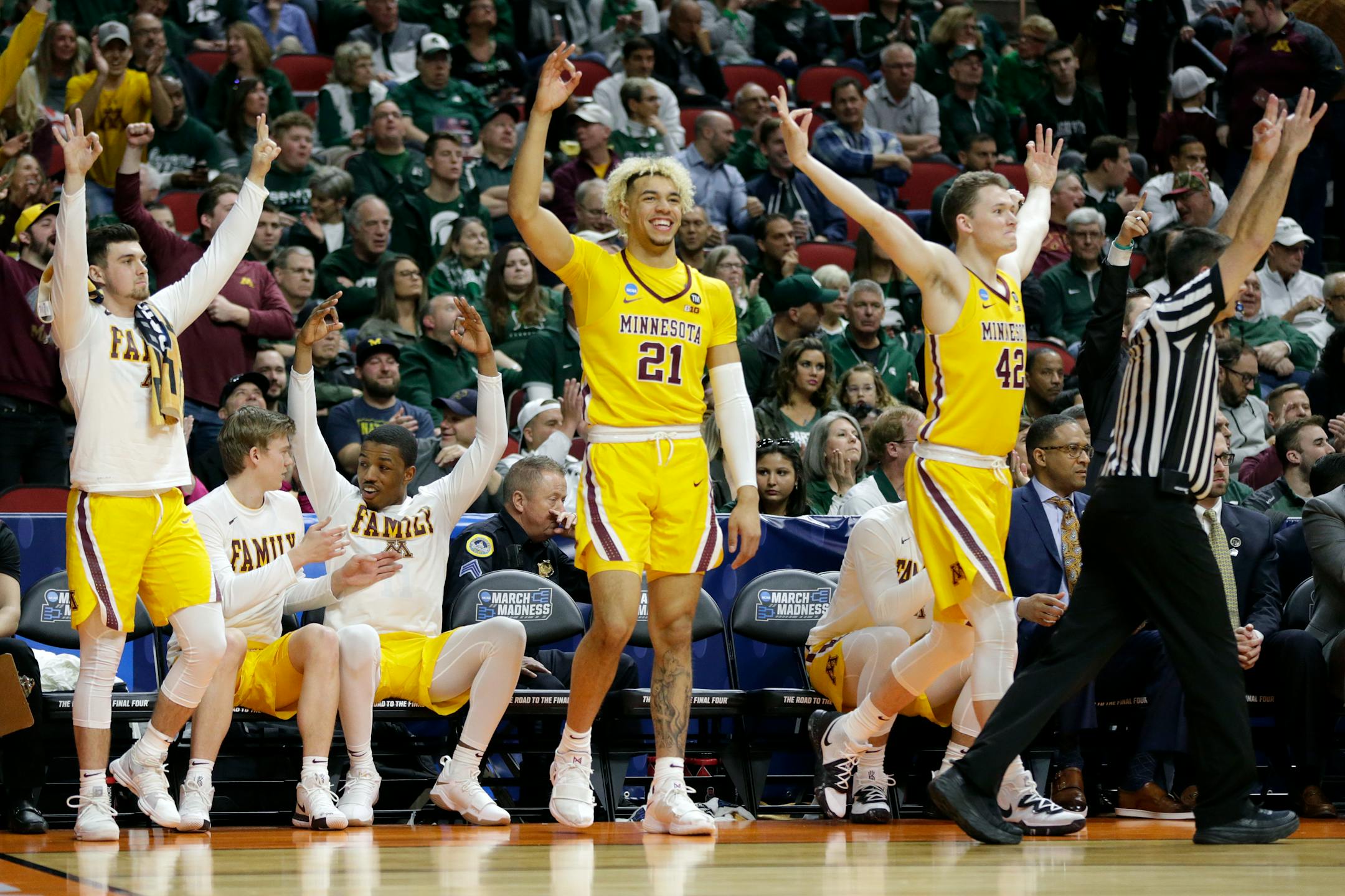 The Gophers bench celebrates a three-point basket during the second half against Louisville