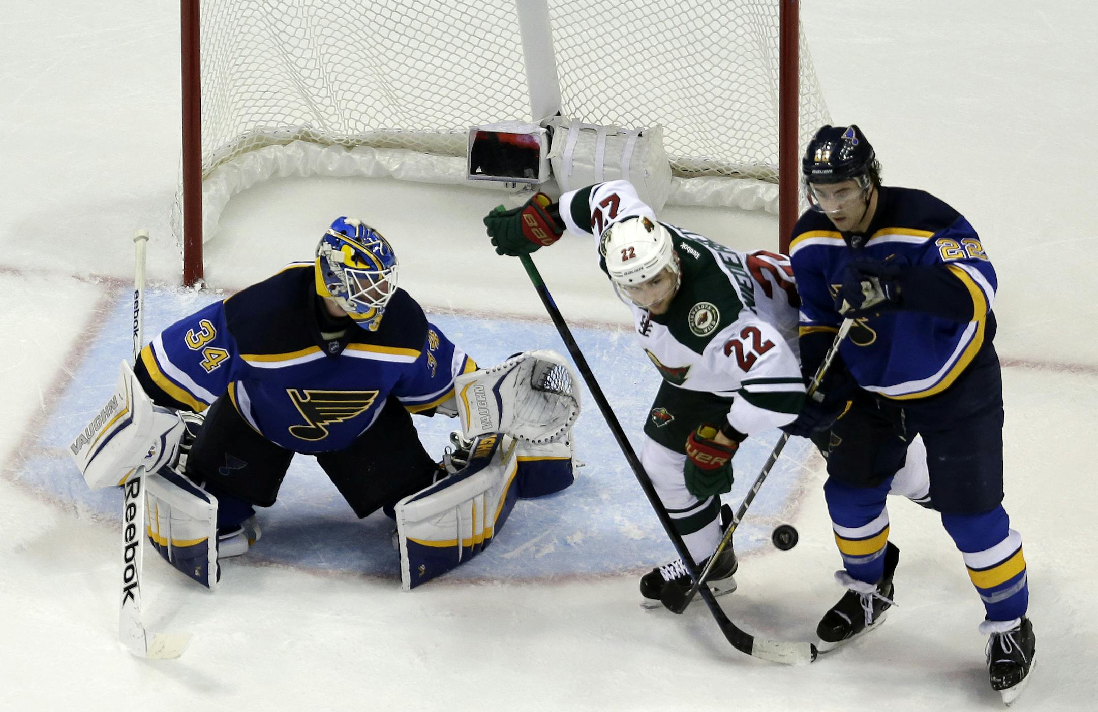 Minnesota Wild's Nino Niederreiter (22), of Switzerland, keeps his eye on a loose puck as St. Louis Blues goalie Jake Allen, left, and Kevin Shattenkirk defend during the second period in Game 5 of an NHL hockey first-round playoff series, Friday, April 24, 2015, in St. Louis. (AP Photo/Jeff Roberson)