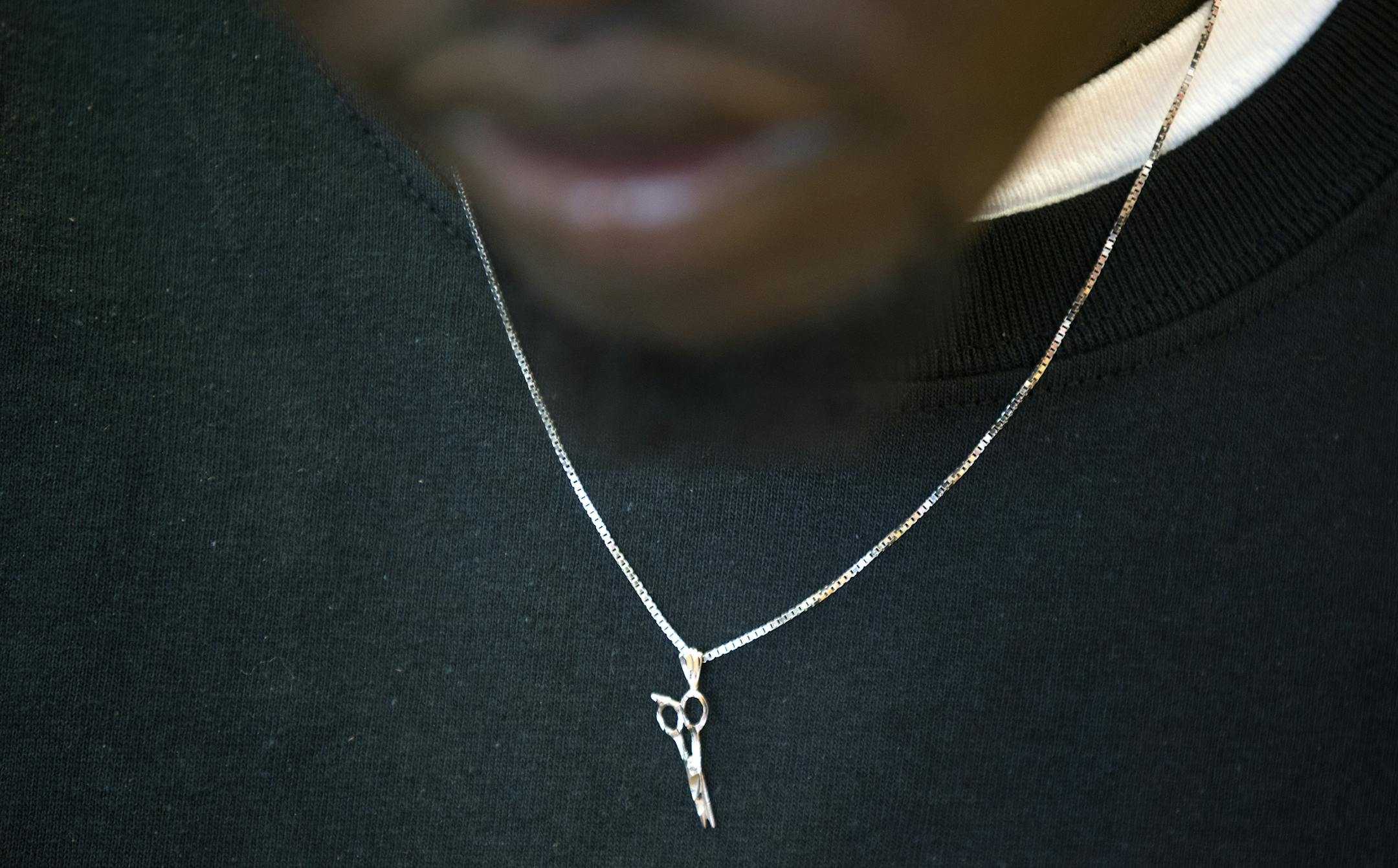 Akeem Akway sports a scissors necklace on the opening day of his new business Akway's Sports Barbershop in Spring Lake Park on Friday, May 8, 2015. LEILA NAVIDI leila.navidi@startribune.com / BACKGROUND INFORMATION: Akeem Akway, a former Fridley basketball player, used to cut his teammates' hair in the locker room.