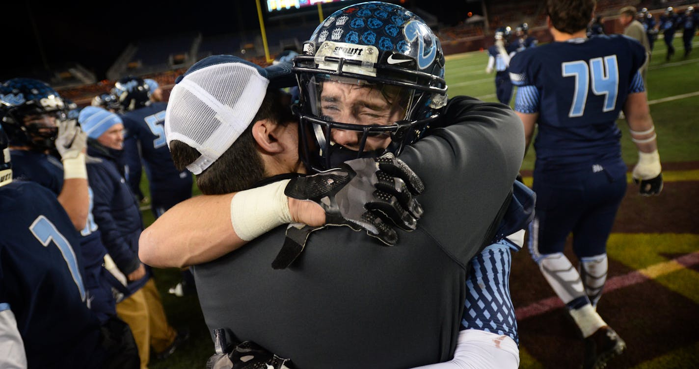 Becker tailback Austin Rassmussen (20) was overcome with emotion while hugging assistant coach Jasper Schmidt after Becker's 35-14 victory over South Saint Paul. ] (AARON LAVINSKY/STAR TRIBUNE) aaron.lavinsky@startribune.com Becker played South St. Paul in the Class 4A championship game on Friday, Nov. 13, 2015 at TCF Bank Stadium.