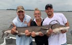 (From left) It took the combined arms of Paul Stay, Danielle Stay and Dustin Stay to hold up this 68-inch lake sturgeon from Lake Kabetogama.